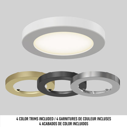 The 5" LED Skylight features a white round ceiling light and comes with 3 interchangeable trim rings in gold, black, and silver. Text below reads "4 color trims included" in English, French, and Spanish.