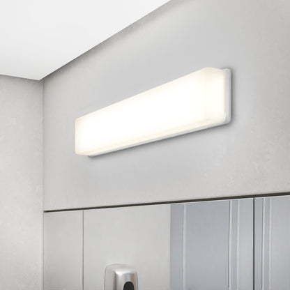 The Aster 27in Energy Star LED Vanity Light, mounted above a bathroom mirror, casts a bright white glow on a light gray wall.