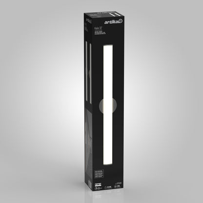 A tall, rectangular black box displays the Artika Kalio Indoor LED Wall Sconce 32" (0-10V, 120-277V) with a vertical cutout showcasing the slim illuminated LED light inside, set against a light gray background.