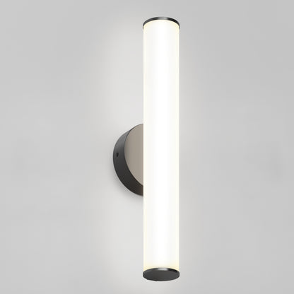 The Kalio Indoor LED Wall Sconce 18" features a vertical frosted glass cylinder and a matte black base, illuminated against a plain light gray background. Suitable for 0-10V dimming and 120-277V installations.