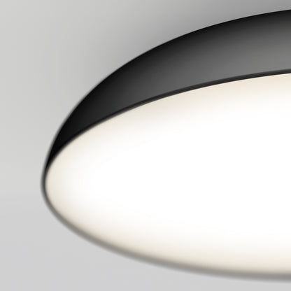 A close-up of the Flint LED Flush Mount, a modern circular ceiling light with a black rim, glowing brightly against a plain white ceiling.