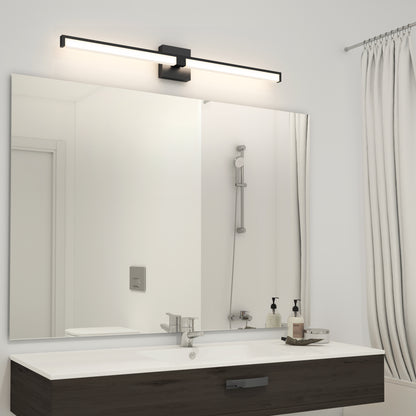 A modern bathroom features a dark wood vanity with a rectangular sink, soap dispensers, and tray. Above the large mirror, the sleek Tivoli 36'' LED Vanity Light is mounted, reflecting the shower area in its glass surface.