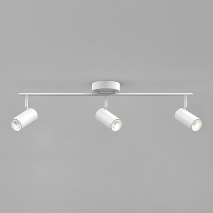 The Alpha LED Track 3-Light features a central round base and three adjustable cylindrical spotlights on a straight horizontal bar, all in a sleek white finish, set against a plain gray background.